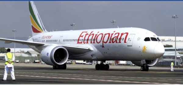 A ground crew member guides an Ethiopian Airlines  at Bole International Airport