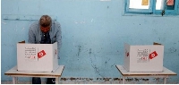 A man votes at a polling station during parliamentary election in Tunis