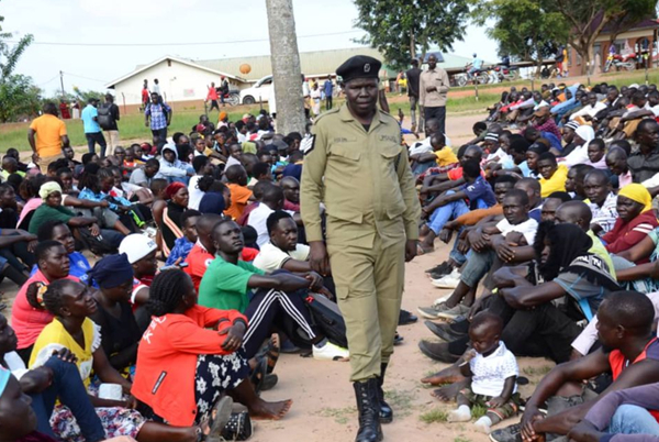 A police officer checks on the applicants who had turned for recruitment exercise in Koboko