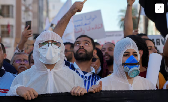 Demonstrators hold a banner as hundreds of Tunisians march through the capital Tunis on Saturday