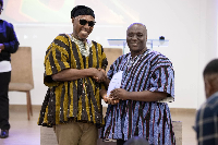 Deputy Minister for Education, Dr Apaak presenting the award to Auberon Jeleel Odoom