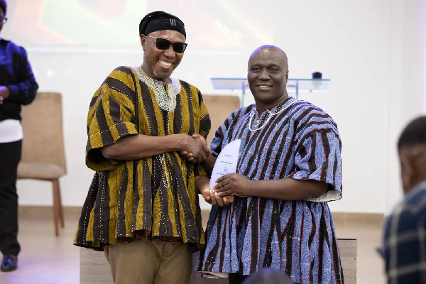 Deputy Minister for Education, Dr Apaak presenting the award to Auberon Jeleel Odoom