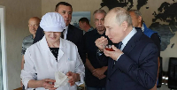 Russia's President Vladimir Putin tastes caviar as he visits Iturup, known in Japan as Etorofu