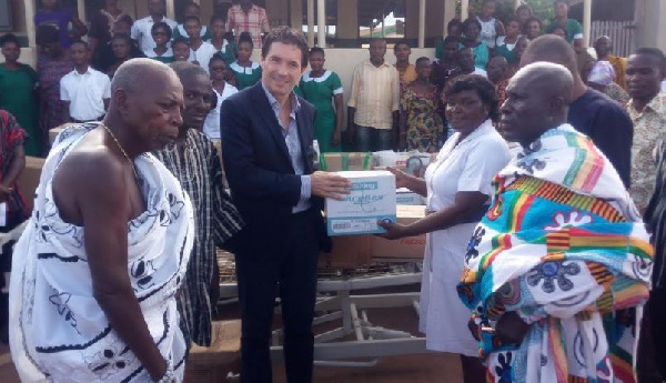 Enrico Biasutti (black suit) presenting medical items to authorities of Axim Hospital