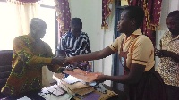A pupil of Kibi MA Experimental School presenting a petition to the MCE