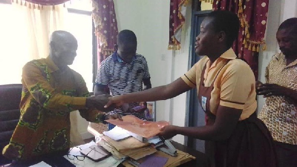 A pupil of Kibi MA Experimental School presenting a petition to the MCE