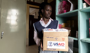 In Kisumu's Kuoyo Hospital, a nurse holds a USAID box of antiretrovirals amid US funding cuts