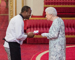 Chef Elijah receiving his award from Queen Elizabeth II