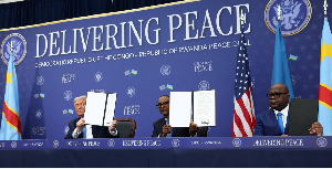 From left: Donald Trump, Paul Kagame and Felix Tshisekedi hold a signed document
