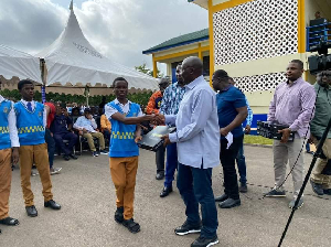 Vice President Dr Mahamudu Bawumia presenting a student with a tablet