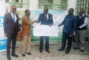 Executive Director of Unibank, Duke Mettle [Middle] presenting the cheque to Dr Bambangi