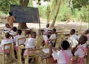 School children learning under a tree because they lack classrooms