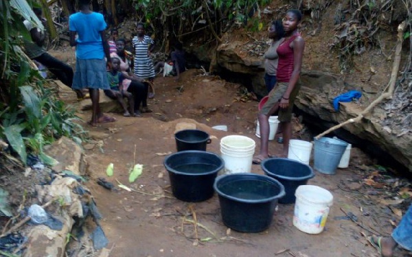 Obo residents scooping water from gutter.