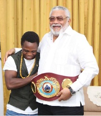 Former President  Jerry John Rawlings in a handshake with Bantamweight champion, Isaac Dogboe