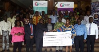 CEO of Opportunity International presenting a dummy cheque to a school proprietor