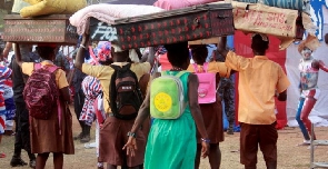 Some Students carrying their luggage to school