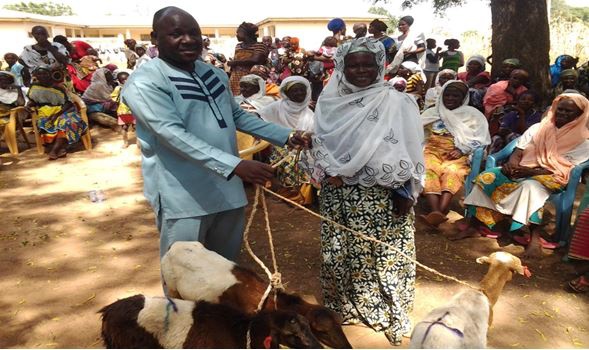 The DCE of Karaga, Mr. Imoro Yakubu presenting the animals to a beneficiary woman at Karaga.