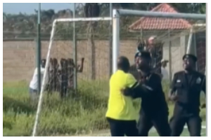 An official clashes with police during the Nations FC vs. Basake Holy Stars match