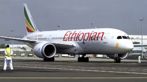 A member of the ground crew directs an Ethiopian Airlines Boeing 787-8 Dreamliner plane