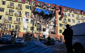 A rescue worker walks in front of a residential building that was heavily damaged after a Russian A rescue worker walks in front of a residential building that was heavily damaged after a Russian