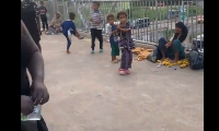 The beggar and her kids sitting on the footbridge