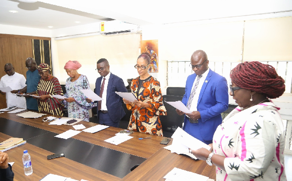 Dzifa Gomashie (R) administering the oath of office to the new members of the board