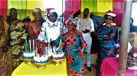 Mrs Morrison (3rd left) being helped by some of the elderly to cut her birthday cake