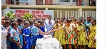 Dr. Osei Yaw Adutwum and some of the school children cutting his cake