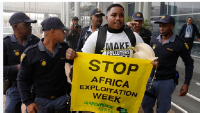 Police officers remove Greenpeace Africa activists protesting at  African Energy Week in Cape Town
