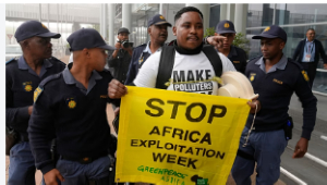 Police officers remove Greenpeace Africa activists protesting at  African Energy Week in Cape Town