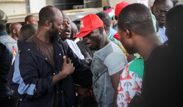 A member of the Agbogbloshie boys [with a red cap] being held to restore calm