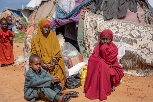 A Somali woman with children from southern Somalia, displaced by drought sits in an open area