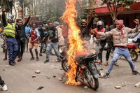 Demonstrators set a motorbike on fire during protests in Nairobi