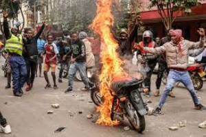 Demonstrators set a motorbike on fire during protests in Nairobi