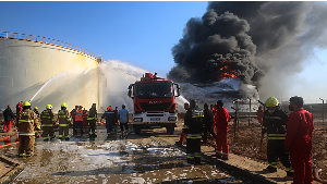 Firefighters work to contain a fire at the Zawiya oil refinery following a drone strike in Zawiya