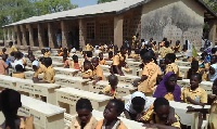 Some of the kids sitting on the new desks