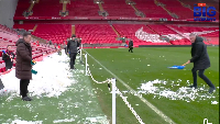 Gary Neville shoveling snow unto the pitch at Anfield