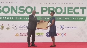 Stephen Amoah presenting laptop to a brilliant student