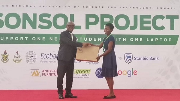 Stephen Amoah presenting laptop to a brilliant student