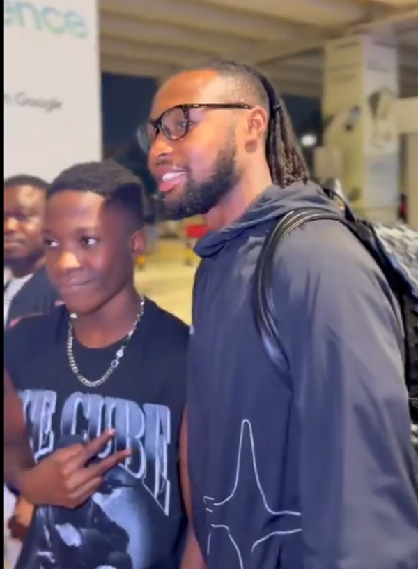 Antoine Semenyo taking a picture with a fan at the airport