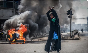 A protester reacts in front of a burning barricade in downtown Nairobi, Kenya, June 25, 2025
