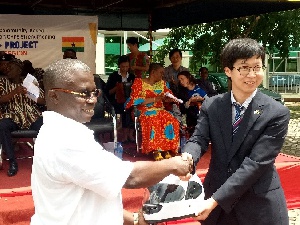 Mr Yukyum Kim (right) presenting a crash helmet to Dr Winfred Ofosu (left)
