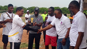 Richmond Believer Alorver presenting the trophy to the team