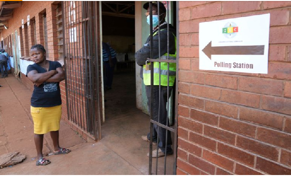 A woman waits outside a polling station in Harare on August 23, 2023