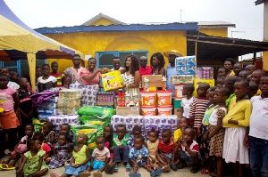 Nana Ama Mcbrown  with Maxwell, others presenting the items to Royal Seed Home and School