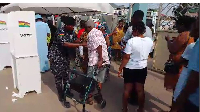 Police officer assisting an elderly man to vote