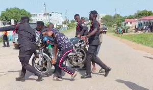 A picture of the Police escorting the motorcycle out of the road