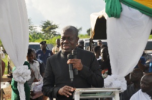 Vice President Amissah-Arthur cutting the ribbon to present the bus to the school authorities.
