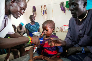 A medical officer from Doctors Without Borders attends to a child with malnutrition