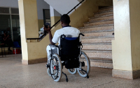 A disabled man user navigates an inaccessible public facility in Ghana